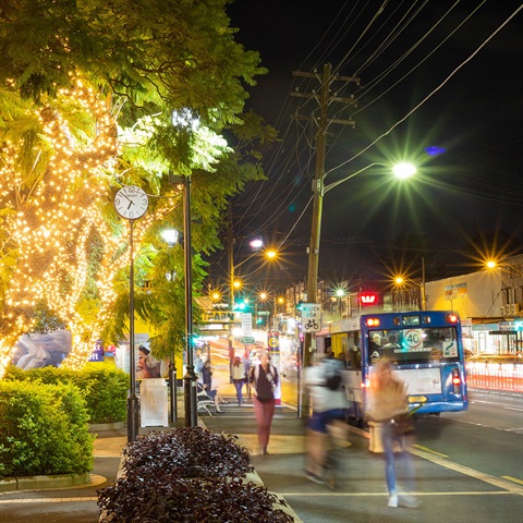 Gladesville street at night with bus and people and fairy lights in trees