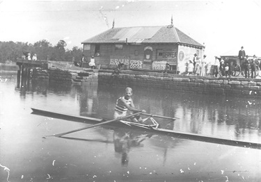 Jim Stanbury in racing skiff in front of Ryde wharf, 1900.  ‘Big’ Jim Stanbury was a sculler who settled in Ryde after marrying Dolly Jordan, daughter of the proprietor of the Royal Hotel. He first won the world title in 1891 and held it until 1896. Ryde Library Service. Acc. 5159091. Stanbury family / 1