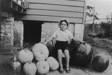 Gordon Millar with melons and pumpkins grown by his father William at the back of the Millar family home in High Street, Gladesville around 1924. Ryde Library Service. Acc. 5481279. Millar family / 2