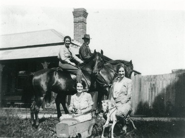 Ernest Benson, an unidentified woman on a horse with Val Archer in toy car and Edna Benson on rocking horse ‘Comet’ at Bensonville 1920s. Ryde Library Service. Acc. 7516215. Benson family / 7
