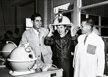 Miss Australia, Tanya Verstak, trying on a Constellation vacuum cleaner during a tour of the Hoover Factory, Meadowbank 1960s. What people are asked to do for a publicity shot! Ryde District Historical Society. Image 5295; negative 203/15.