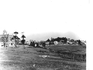 Hatton’s Flat, 1912. Named after Joseph Hatton, the First Fleeter who was the original land grantee in this area, this image is looking south. The large building on the left hand side is the Hampton Court Tourist Residential at what would now be the corner of Devlin Street and Pope Street. The central large stand of trees on the horizon indicates the location of St Anne’s Church with the Ryde School of Arts just visible in front. Ryde Library Service. Acc. 4892283. Ryde / 1.
