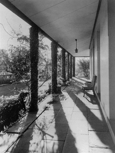 View of the front verandah of The Hermitage, Denistone East, 1941 with ficus covered wooden pillars. The Hermitage, located in Pennant Avenue, Denistone, was built by John and Ellen Blaxland in the 1840s. The Nicholson family lived there in the early 20th century. Catherine Nicholson, on marriage, became Catherine Hamlin, who co-founded the Fistula Hospital in Ethiopia. Once used as a research facility of the CSIRO, it has now reverted to its original use as a family home. Ryde Library Service. Acc. 5483263. The Hermitage (Denistone East) / 11.