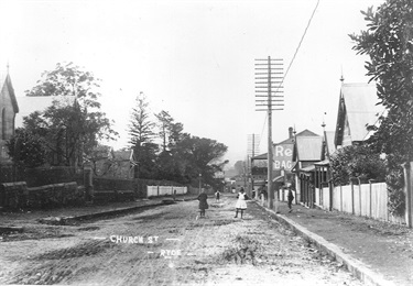 Children playing in Church Street, Ryde around 1912. Looking north towards the intersection of Parkes Street (now Blaxland Road). On the extreme left is the new Methodist Church, then the Oddfellows Hall. The tall trees on the left-hand side are the long established plantings surrounding the original St Anne’s Rectory. Ryde Library Service. Acc. 557823A. Church Street, Ryde / 15.