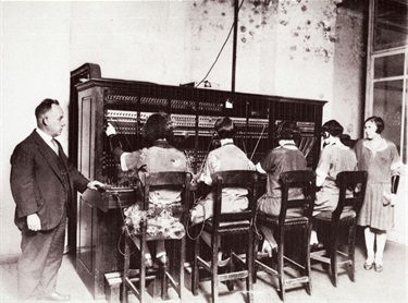 Telephonists at work in Gladesville Post Office in 1920s. In the early days of telephony, telephone calls were connected at manual switchboards by switchboard operators who inserted phone plugs into the appropriate jack. Even though most private homes would not have had a telephone in the 1920s, at least four young women were employed here with two stern looking supervisors! Ryde District Historical Society. Image 9202; negative 330/8.