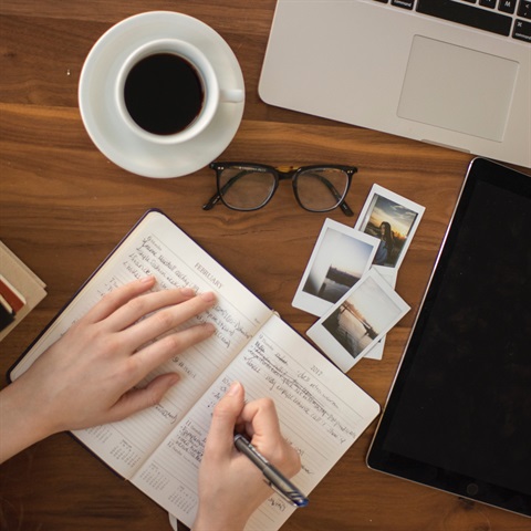 Photo of a person writing in a notebook