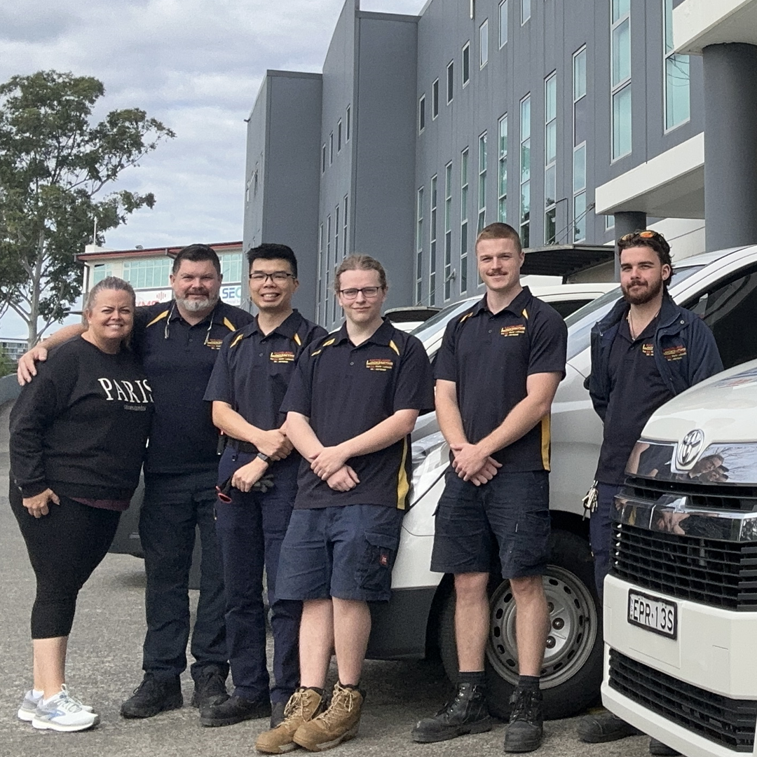 A team of locksmiths stand by a van