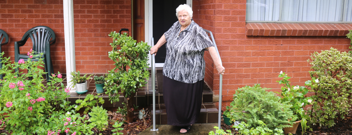 lady outside house holding hand rail