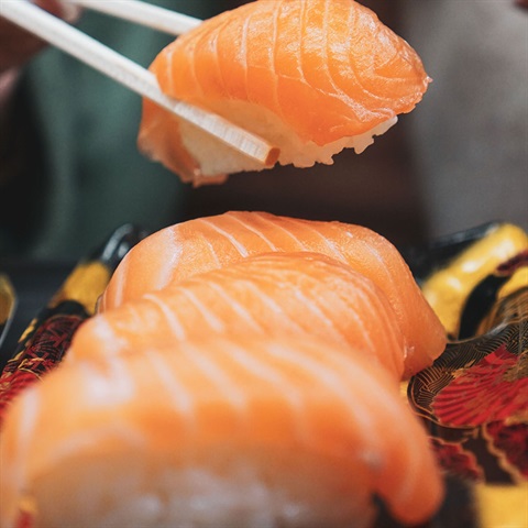 Sushi being held by chopsticks