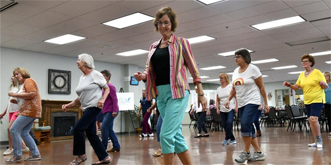 A group of women senior in a line dancing class