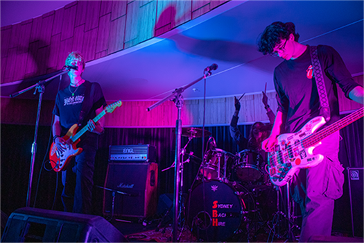 A band of three play on stage