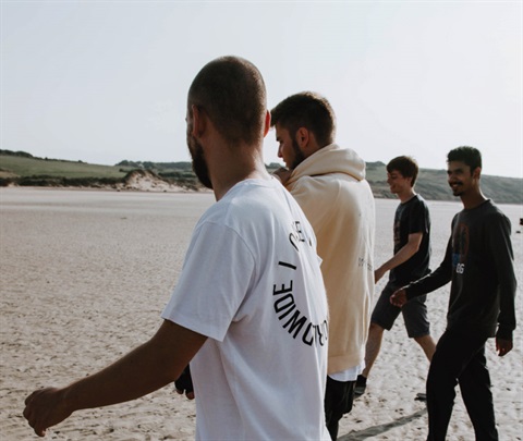 Bunch of men walking together on the beach
