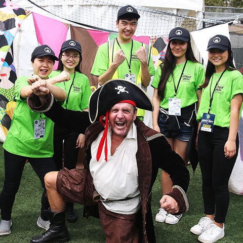 Group of volunteers with man in pirate costume at event