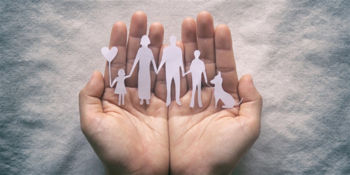 Hands with cut-out paper of family