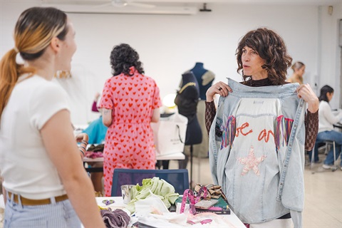 Two women discussing a flipped denim jacket