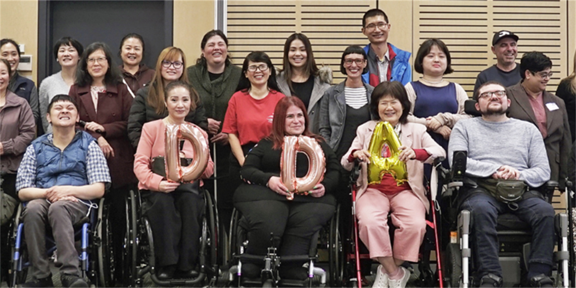 Group of people pose for the camera holding the letters D D A