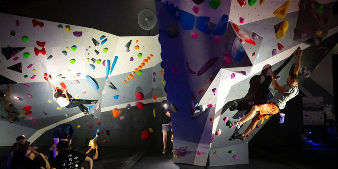 View of people climbing walls of an indoor rock climbing venue, 