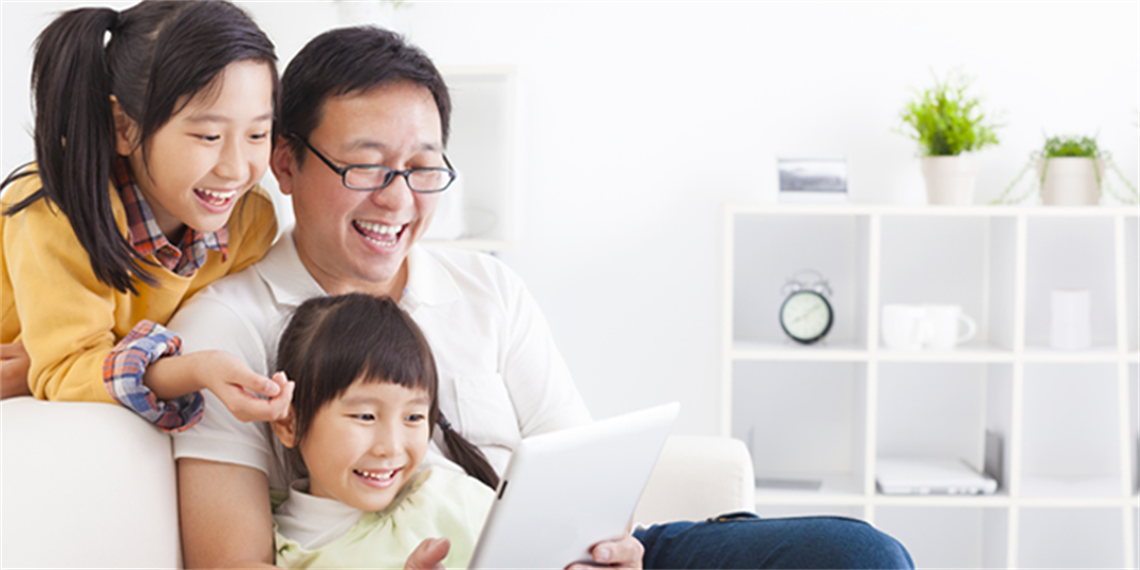 Dad with kids playing on a tablet