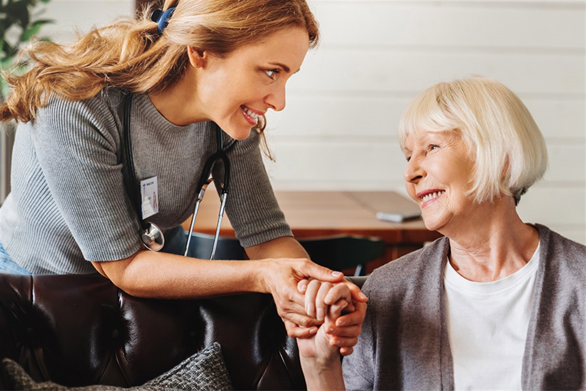 Young lady holding the hand of a more senior woman