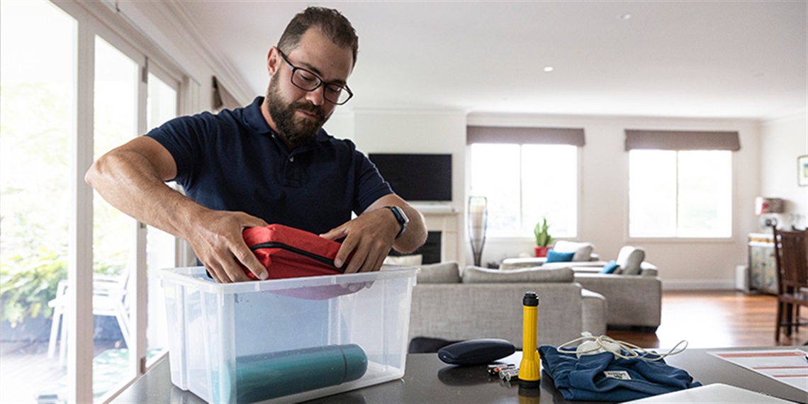 Image of a man putting an emergency kit together