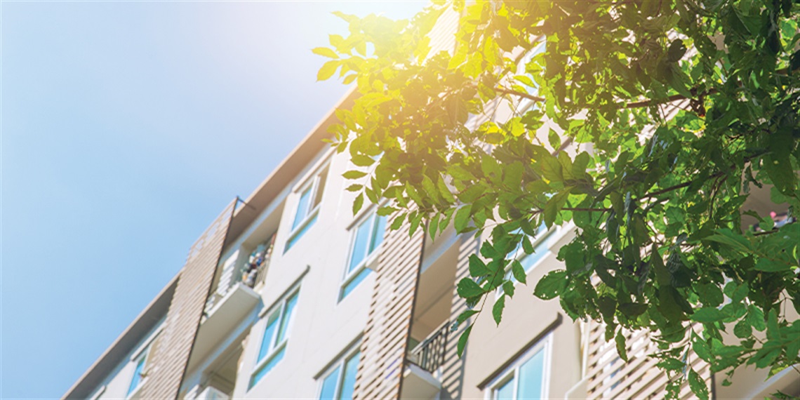 Image of an apartment featuring a tree in the foreground