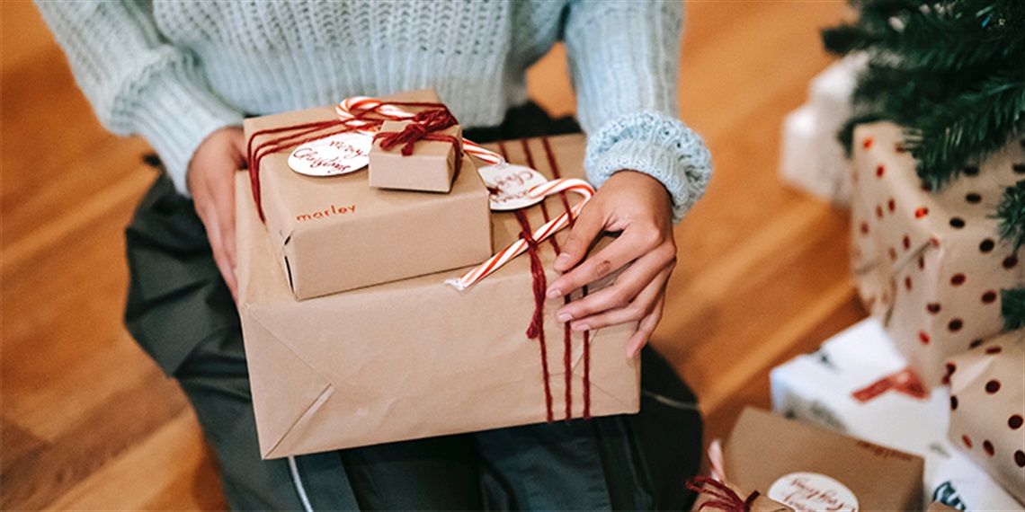 Image of a person holding wrapped gifts