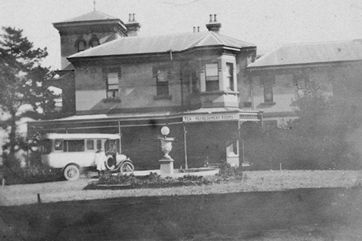 Old photo of bus parked by a house on Putney Park