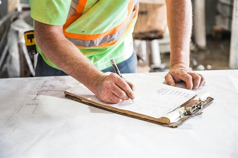 Builder filling out paper form