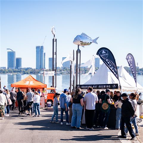 Crowds of people standing at different outdoor festival stalls
