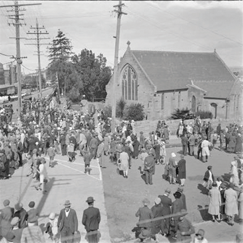 Crowds of people gathered next to a church