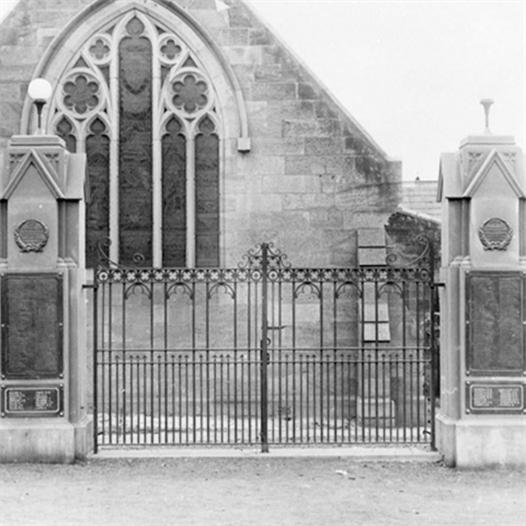 Black and white photo of a church-like building with a front gate