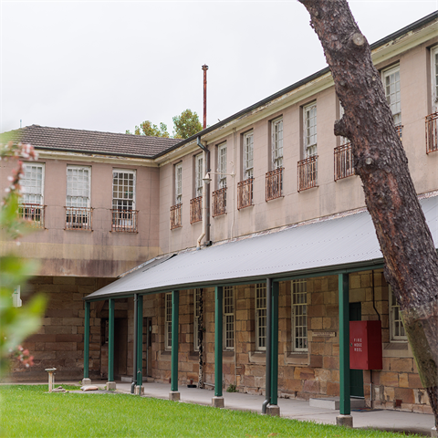 An old brick building with a small strip of lawn