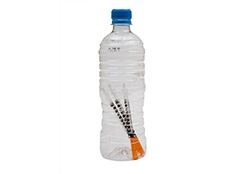 Needles and syringes inside plastic bottle