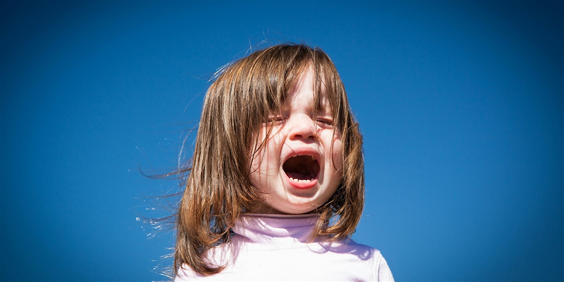 Crying girl against blue background